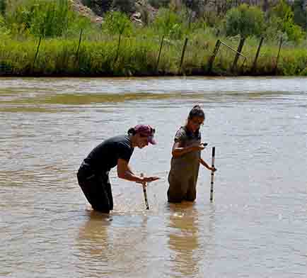 J Ortiz with the Española public schools gifted and talented program, and one of the students look at rocks they found on the riverbed, Sept. 6, 2017.