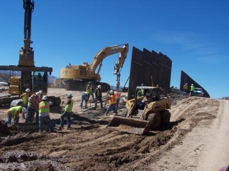 Workers work on constructing the border fence between the United States and Mexico.